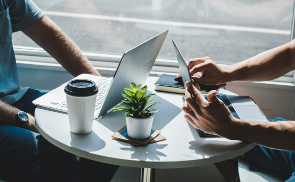 two people having coffee working on laptops